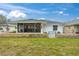 Lush backyard featuring stone accents, screened-in lanai, and lush green lawn at 734 Canberra Rd, Winter Haven, FL 33884