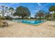 This spacious community pool is surrounded by lots of chairs, tables and umbrellas at 734 Canberra Rd, Winter Haven, FL 33884