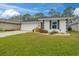 Single-Gathering home boasts a well-manicured lawn, driveway, and an attached garage at 734 Canberra Rd, Winter Haven, FL 33884