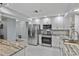 Updated kitchen with stainless steel appliances, granite countertops, and white cabinetry at 734 Canberra Rd, Winter Haven, FL 33884