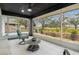 Relaxing screened-in lanai with tiled floor, ceiling fan, and panoramic views of the green landscape at 734 Canberra Rd, Winter Haven, FL 33884