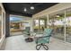 Relaxing screened-in lanai with comfortable seating, a ceiling fan, and views of the well manicured garden at 734 Canberra Rd, Winter Haven, FL 33884