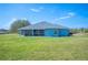 Wide shot of home and backyard featuring a screened patio, lush lawn and plenty of space at 9461 Redhawk Bend Ln, Lakeland, FL 33810