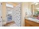 The bathroom boasts a door to the patio and a large, tiled shower behind a patterned curtain at 9461 Redhawk Bend Ln, Lakeland, FL 33810