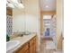 The bathroom is equipped with a door leading outside and a large granite topped vanity at 9461 Redhawk Bend Ln, Lakeland, FL 33810