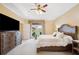Bright bedroom featuring a tray ceiling, wood furnishings, and access to the backyard at 9461 Redhawk Bend Ln, Lakeland, FL 33810