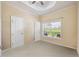 Bright bedroom features neutral walls, tray ceiling, and a window overlooking the well-maintained lawn at 9461 Redhawk Bend Ln, Lakeland, FL 33810