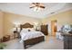 Comfortable bedroom with a ceiling fan, tray ceiling, and neutral color scheme at 9461 Redhawk Bend Ln, Lakeland, FL 33810