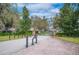 Community entry gate with stone columns, mature trees, and well-maintained landscaping at 9461 Redhawk Bend Ln, Lakeland, FL 33810