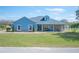 Charming single-story home featuring blue exterior, well-maintained lawn, and stone accents at 9461 Redhawk Bend Ln, Lakeland, FL 33810