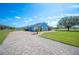 Attractive single-story home with a brick driveway, blue exterior, and lush green lawn at 9461 Redhawk Bend Ln, Lakeland, FL 33810