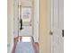 A hallway with wood floors and a blue rug leads to a room with a large window at 9461 Redhawk Bend Ln, Lakeland, FL 33810