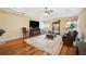 Open living room with a mounted television, open kitchen and hardwood flooring at 9461 Redhawk Bend Ln, Lakeland, FL 33810