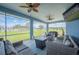 Cozy screened patio with comfortable seating, a gas fire pit, and views of the expansive backyard at 9461 Redhawk Bend Ln, Lakeland, FL 33810