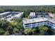 Aerial view showcasing building architecture with surrounding green trees at 1100 Martinique Dr # 106, Winter Haven, FL 33884