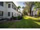 Well-maintained backyard featuring lush green grass, a patio, and lots of shade trees at 1100 Martinique Dr # 106, Winter Haven, FL 33884