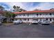 Exterior view of a well-maintained two-story building showcasing parking spaces and some lush greenery at 1100 Martinique Dr # 106, Winter Haven, FL 33884