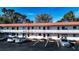 Exterior of a two-story building with a red roof, white walls, car park, and lush trees at 1100 Martinique Dr # 106, Winter Haven, FL 33884