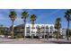 Exterior view of a multi-story building featuring a white exterior, multiple balconies, and tropical landscaping at 1100 Martinique Dr # 106, Winter Haven, FL 33884