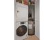 Laundry closet with a stacked washer and dryer, water heater, and the HVAC system at 1103 Country Club Dr # A-3, Lake Wales, FL 33898