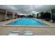 Community swimming pool surrounded by lounge chairs and adjacent buildings at 1130 N Lake Parker Ave # E231, Lakeland, FL 33805