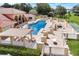 Resort-style community pool area with lounge chairs, pergolas, and shuffleboard court for outdoor enjoyment at 123 Morning Glory Cir, Winter Haven, FL 33884