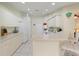 Bright kitchen featuring white cabinets, a breakfast bar, and tile floors that extend to the laundry area at 123 Morning Glory Cir, Winter Haven, FL 33884