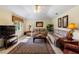 Comfortable living room with neutral-colored couches, decorative lamps, and a large area rug on tile flooring at 123 Morning Glory Cir, Winter Haven, FL 33884