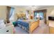 Bright main bedroom with a ceiling fan, a large bed, and windows with blue curtains at 123 Morning Glory Cir, Winter Haven, FL 33884