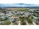 An aerial view shows a house in a neighborhood surrounded by trees and with a lake in the distance at 125 Bergen Cir, Auburndale, FL 33823