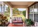 Inviting front porch seating area with an outdoor view of the lush, green neighborhood at 125 Bergen Cir, Auburndale, FL 33823