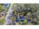 An aerial view of a house with a partially collapsed roof and fire damage, surrounded by mature trees and a paved street at 1325 4Th Ne St, Winter Haven, FL 33881
