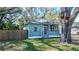 Quaint home featuring a screened porch with a lush green lawn and mature trees at 1325 4Th Ne St, Winter Haven, FL 33881