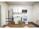 Bright kitchen with stainless steel refrigerator, white cabinetry, range, and microwave at 1325 4Th Ne St, Winter Haven, FL 33881