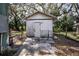 Exterior shot of outbuilding needing complete renovation with weathered walls and overgrown yard at 1325 4Th Ne St, Winter Haven, FL 33881