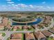 Aerial view of the neighborhood featuring homes around a pond with surrounding landscape at 1336 Oakmont Dr, Winter Haven, FL 33884