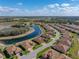 Aerial view of a neighborhood featuring homes, streets, and a winding pond at 1336 Oakmont Dr, Winter Haven, FL 33884