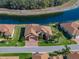 Aerial view of residence, showcasing its brick driveway, manicured landscaping, and proximity to a pond at 1336 Oakmont Dr, Winter Haven, FL 33884