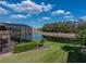 Landscaped backyard with screened porch overlooking a peaceful pond, and lawn at 1336 Oakmont Dr, Winter Haven, FL 33884