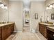 Spacious bathroom featuring dual vanities with granite tops and a central hallway at 1336 Oakmont Dr, Winter Haven, FL 33884