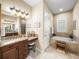 Bathroom featuring double vanity, granite countertops, a soaking tub, and a separate walk-in shower at 1336 Oakmont Dr, Winter Haven, FL 33884