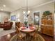 Cozy dining area with a round wooden table, chairs, and a cabinet perfect for intimate meals at 1336 Oakmont Dr, Winter Haven, FL 33884