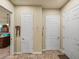 Hallway with neutral paint, tile flooring, and white doors leading to various rooms at 1336 Oakmont Dr, Winter Haven, FL 33884