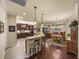 Open concept kitchen featuring granite counters, wood cabinets, and bar seating flowing into the dining and living areas at 1336 Oakmont Dr, Winter Haven, FL 33884