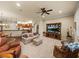 Spacious living room featuring plush carpeting, a ceiling fan, and an entertainment center at 1336 Oakmont Dr, Winter Haven, FL 33884