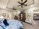 Bedroom featuring tray ceilings, ceiling fans, decorative furniture, and doorway to en-suite bathroom at 1336 Oakmont Dr, Winter Haven, FL 33884