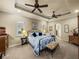 Inviting bedroom with tray ceiling, ceiling fans, carpeted floor, and natural light from the shuttered windows at 1336 Oakmont Dr, Winter Haven, FL 33884