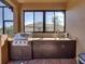 Outdoor kitchen with stainless steel grill, granite countertops, and dark cabinets at 1336 Oakmont Dr, Winter Haven, FL 33884
