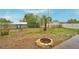 View of backyard with a fire pit and mature landscaping, creating an inviting outdoor space at 1412 Covington Ct, Lake Wales, FL 33853
