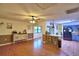 Cozy living room featuring wood floors, ceiling fan, and seamless transition to kitchen area at 1412 Covington Ct, Lake Wales, FL 33853